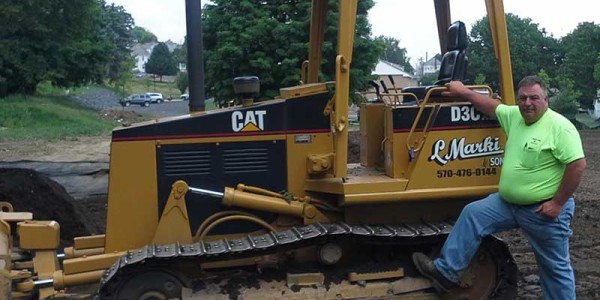 Picture of Bob Marki, President of L. Marki and Son, Inc. in front of a bulldozer.