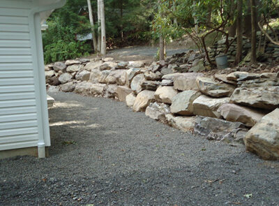 a rock wall with a shaled area surrounding it