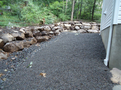 A rock retaining wall with a shale mulch around