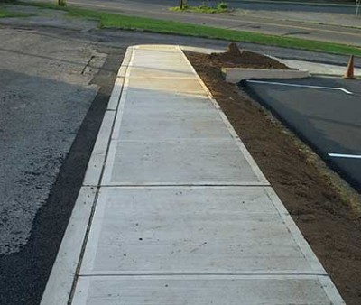 Picture of sidewalk and grading along the side of the second smaller parking lot